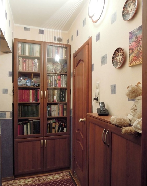 Книжный шкаф в коридоре у стены