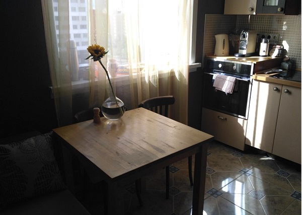 Квадратный деревянный стол в однокомнатной квартире